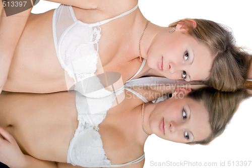 Image of The young beautiful woman and her reflection in a mirror