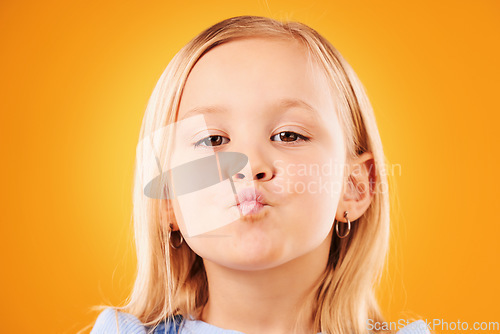 Image of Portrait, kiss and girl child in studio with love, expression or gesture against an orange background space. Faces, kisses and kid with emoji facial expression for fun, personality or cute affection