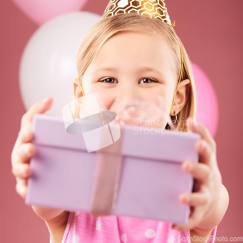 Image of Birthday, gift and portrait of a child with balloons in studio for party, holiday or happy celebration. Face of excited girl kid on a pink background giving box, present or surprise package in hands