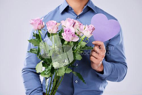 Image of Flowers, man and heart in studio for love on grey background, roses and gift for thank you or present. Bouquet, person and purple paper frame, care and support for valentines day, date or offer