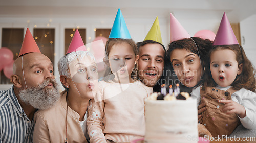 Image of Happy birthday, gift and big family blowing candles with cake in a home party, event and celebration together. Mother, father and grandparents excited for surprise gathering with children or kids