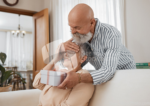 Image of Senior couple, gift and sofa with eyes covered for surprise, anniversary or birthday in home living room. Elderly man, woman and present in box for celebration, marriage or party with love on couch