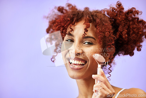 Image of Beauty studio, portrait and happy woman with roller for facial massage tools, skincare treatment or anti aging routine. Jade quartz stone, cosmetics face product and model smile on purple background