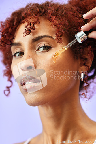 Image of Skincare, portrait and woman with face serum in a studio for natural, beauty and cosmetic routine. Self care, health and female model from Colombia with facial oil for hydration by purple background.