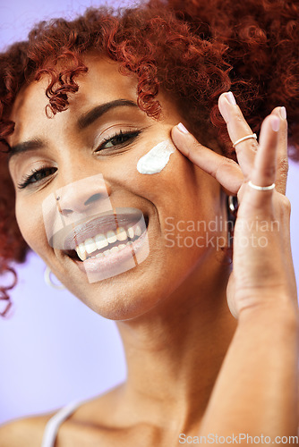 Image of Beauty studio, portrait and happy woman with cream application, cosmetics treatment or collagen product. Moisturizer, face hydration and model with acne creme, ointment or lotion on purple background