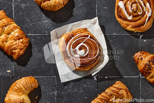 Image of assorted pastries on dark grey old tiles background