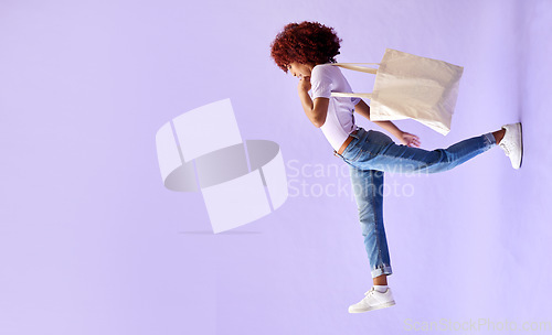 Image of Fashion, shopping and a woman walking on mockup in studio on a purple background for advertising. Retail, commerce and orientation with a young customer carrying bags on banner space for marketing