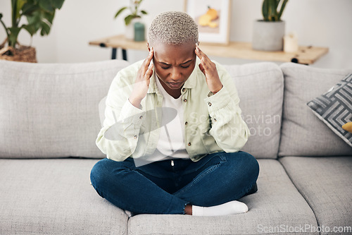 Image of Stress, headache and pain with a black woman on a sofa in the living room of her home for mental health. Anxiety, burnout or vertigo and a young person in an apartment with depression or a migraine