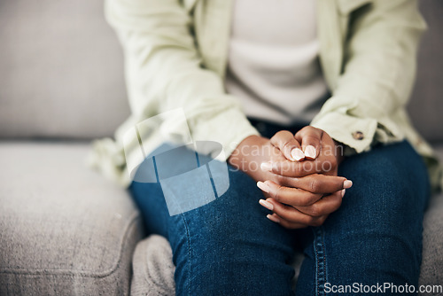 Image of Anxiety, hands and woman on a sofa with stress, fear or worry for mental health or domestic abuse in her home. Psychology, zoom and female with depression, bipolar or scared of gender based violence