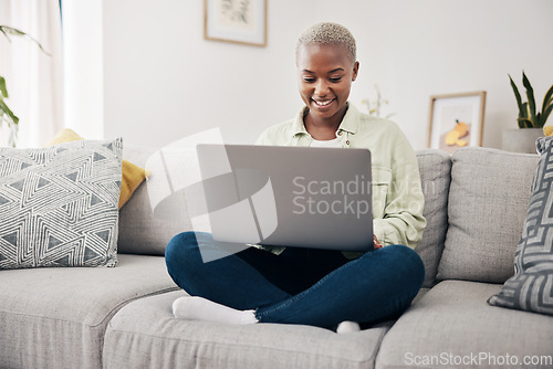 Image of Happy, relax and a black woman on the sofa with a laptop for a movie, streaming a show or chat. Smile, house and an African girl typing on a computer on a couch for an email, communication or a blog