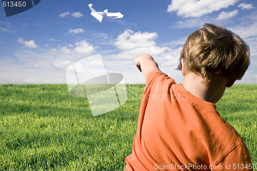 Image of young boy flying a paper plane