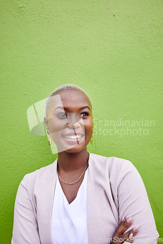 Image of Happy, crossed arms and young black woman by a green wall with classy and elegant jewelry and outfit. Happiness, smile and African female model with positive and confident attitude with mockup space.