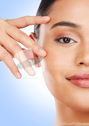 Image of Half face, closeup or woman with skincare, cosmetics or dermatology on a blue studio background. Portrait, person or model with beauty, luxury or wellness with self care, shine or glow with treatment