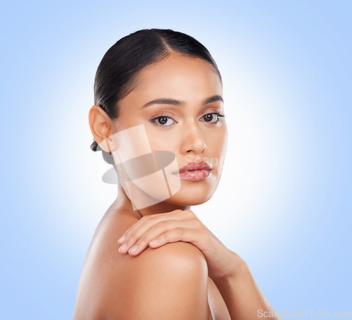 Image of Portrait, glow and a woman with skincare on a blue background for wellness, beauty and health. Moisture, natural and a girl or model touching skin for cosmetics, dermatology or grooming on a backdrop