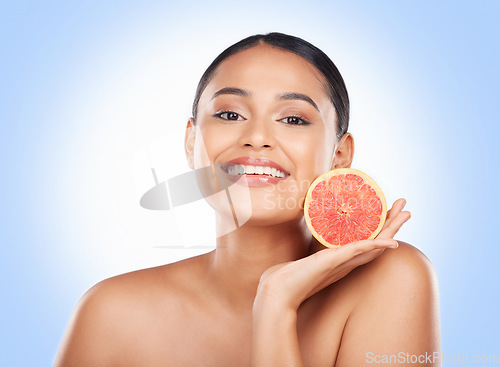 Image of Beauty skincare, portrait and happy woman with grapefruit treatment results, natural self care or fruit benefits. Vitamin C product, eco friendly cosmetics or studio face of person on blue background