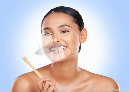 Image of Portrait, woman and brushing teeth in studio for dental care, beauty or healthy smile on blue background. Happy model, bamboo toothbrush and cleaning mouth for oral hygiene, mint breath or gingivitis