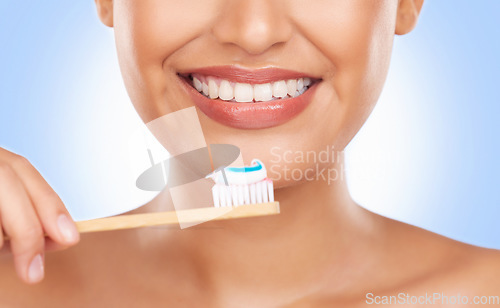 Image of Brushing teeth, toothpaste and dental, woman and health with wellness isolated on blue background. Closeup, mouth and bamboo toothbrush, oral care and orthodontics with hygiene and grooming in studio