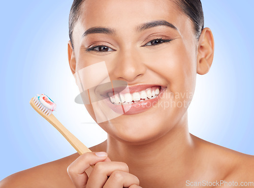 Image of Happy portrait, woman and toothbrush on blue background for dental cleaning, gingivitis and beauty in studio. Model, toothpaste and brushing teeth with bamboo for oral hygiene, healthy smile and care