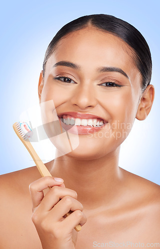 Image of Happy woman, portrait and toothbrush in studio for dental cleaning, gingivitis or gums on blue background. Face of model, toothpaste and brushing teeth with bamboo for oral hygiene, healthy and smile