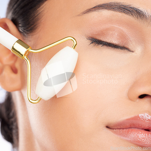 Image of Woman, face roller and closeup for beauty, healthy skincare benefits and aesthetic dermatology. Model, crystal cosmetics product and facial massage tools for lymphatic drainage, collagen and shine