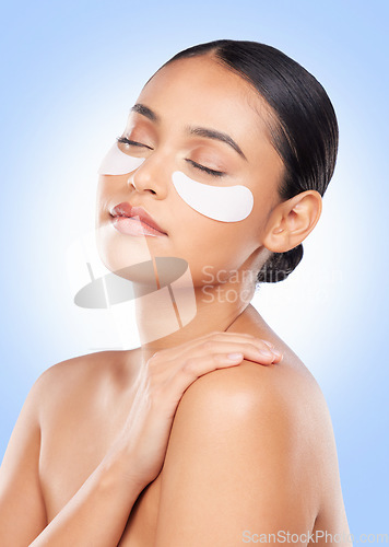 Image of Skincare, beauty and woman with collagen pads for anti aging or skin glow on blue background. Cosmetics, facial detox and face of model with luxury mask or eye product for dermatology pads in studio.