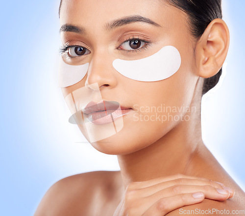 Image of Skincare, portrait and woman with eye patch for anti aging luxury skin glow on blue background. Cosmetics, facial detox and face of model with solution or collagen product for dermatology in studio.