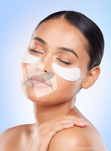 Image of Skincare, beauty and woman with eye patch for anti aging or skin glow on blue background. Cosmetics, facial detox and face of model with luxury mask or collagen product for dermatology pad in studio.