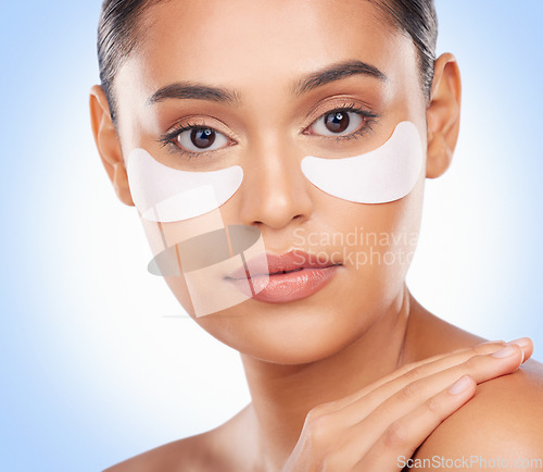 Image of Skincare, portrait and woman with collagen patch for anti aging luxury skin glow on blue background. Cosmetics, facial detox and face of model with solution or eye product for dermatology in studio.