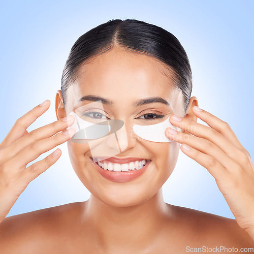 Image of Skincare, eye mask and portrait of happy woman with collagen pad for anti aging skin glow on blue background. Cosmetics, facial beauty and face of model with patches or mask for dermatology in studio