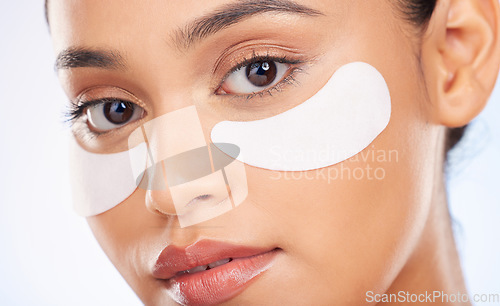 Image of Portrait, skincare and woman with eye patch for anti aging or skin glow for beauty on studio background. Cosmetics, facial detox and face of model with pads or collagen mask for dermatology product.