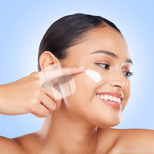 Image of Face makeup, cream and happy woman with beauty cosmetics glow, self care wellness routine and facial hydration product. Skin treatment, happiness and studio model with sunscreen on blue background