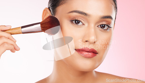 Image of Beauty, makeup and portrait of woman in studio with a brush for cheek blush or foundation for glam routine. Cosmetics, face and young female model with cosmetology product isolated by pink background