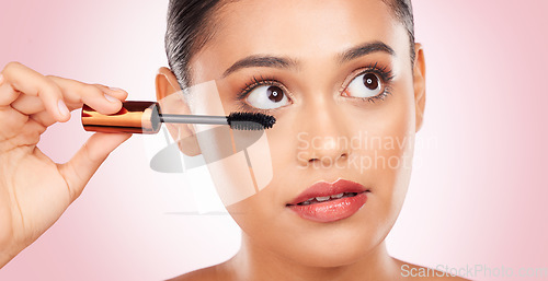 Image of Beauty, woman and mascara for makeup and skincare, cosmetics and application in studio on pink background. Self care, person and brush for eyelash extension, product and aesthetic for volume