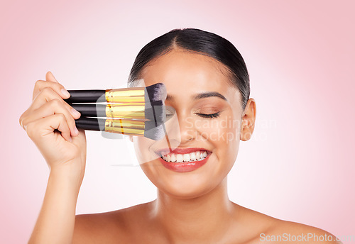 Image of Face makeup, beauty brush and happy woman with cosmetics tools, skincare wellness and facial transformation. Foundation application product, eyes closed and aesthetic studio person on pink background