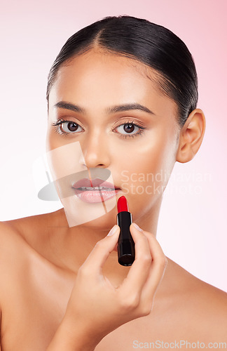 Image of Portrait, beauty and makeup with a woman closeup on a pink background in studio for luxury cosmetics. Aesthetic, lipstick or product with a young model getting ready to apply red lipgloss to her face