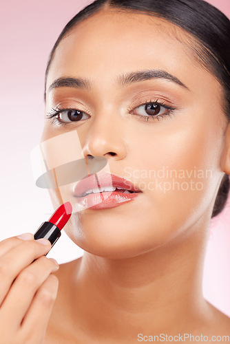 Image of Portrait, beauty and lipstick with a woman closeup on a pink background in studio for luxury cosmetics. Aesthetic, makeup or product with a young model getting ready to apply red lipgloss to her face