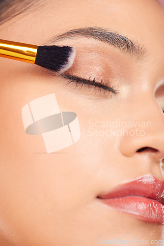Image of Makeup brush, eyes closed and face of woman with eyeshadow product, cosmetics shine and beauty care tools. Foundation application, anti aging treatment and studio closeup of relax skincare model