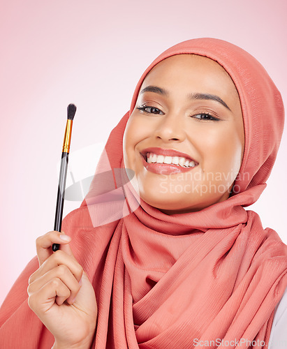 Image of Portrait, happy and muslim woman with makeup brush in studio with cosmetic application on pink background. Halal, skincare and face of female model with beauty, tool or powder, luxury or satisfaction