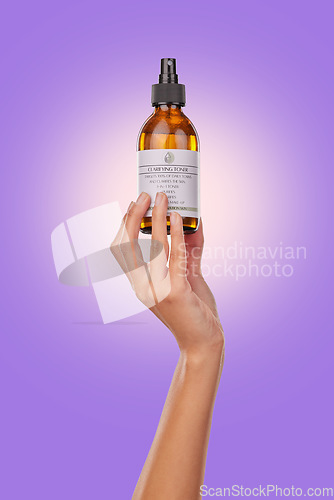 Image of Hand, oil or spray with beauty and skincare, advertising product with dermatology isolated on purple background. Wellness, cosmetics for skin toner and promotion, bottle and hyaluronic acid in studio