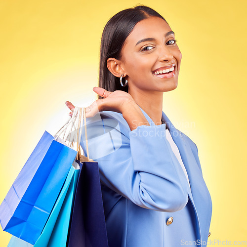 Image of Shopping, bag and portrait of woman as a customer happy for retail fashion isolated in a studio yellow background. Smile, Product, sale and young person with discount, deal or promo on clothes