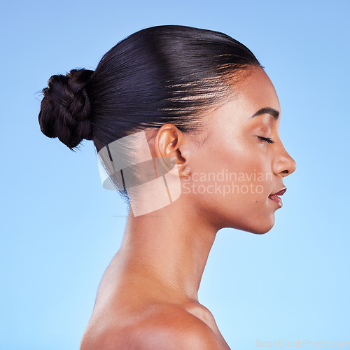 Image of Woman, skincare and profile of natural beauty or shine on skin from cosmetics on blue background in studio with calm model. Dermatology, facial and healthy glow from makeup, wellness or self care