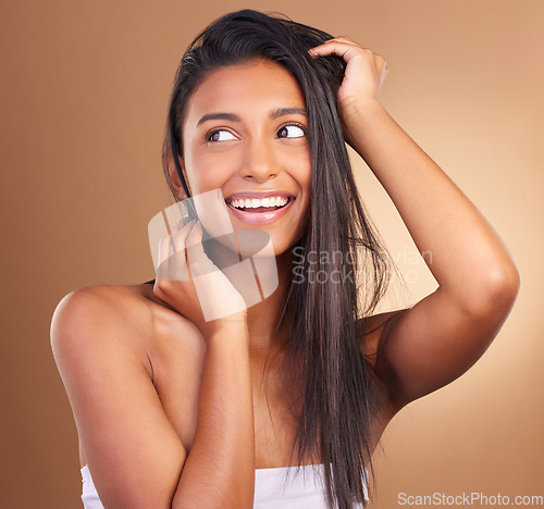 Image of Beauty, smile and woman in studio for hair, growth or texture and shine against a brown background space. Haircare, cosmetics and face of female model happy for shampoo, mask or volume and results