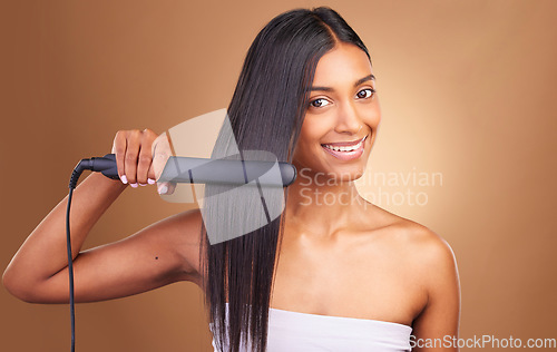 Image of Straightener, hair care and woman portrait with smile and happy from Brazilian treatment in studio. Salon, natural beauty and hairdresser tool for healthy hairstyle and wellness with brown background