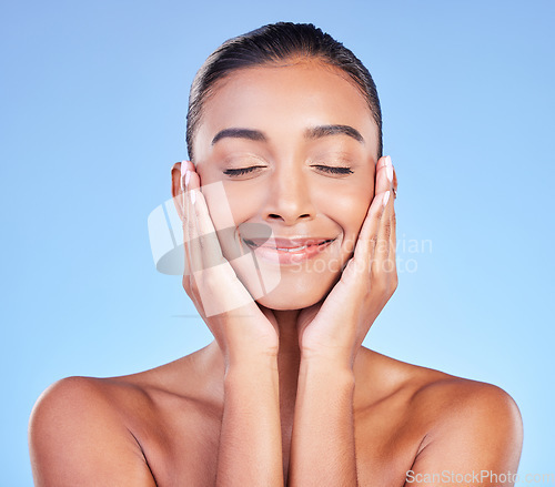 Image of Skincare, peace and hands on face with happy woman in studio with blue background and dermatology or cosmetics. Indian, model and happiness with natural skin and healthy facial glow or beauty care