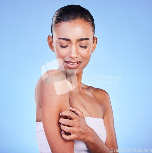 Image of Arm pain, stress and sad woman in studio with arthritis, osteoporosis or emergency on blue background. Shoulder, accident and unhappy lady person with pressure point massage for osteoarthritis relief