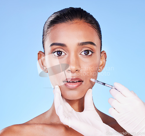 Image of Surprise, woman face and plastic surgery, beauty and injection in portrait, doctor hands on blue background. Cosmetic treatment, wow and liquid collagen in needle syringe with skincare in a studio