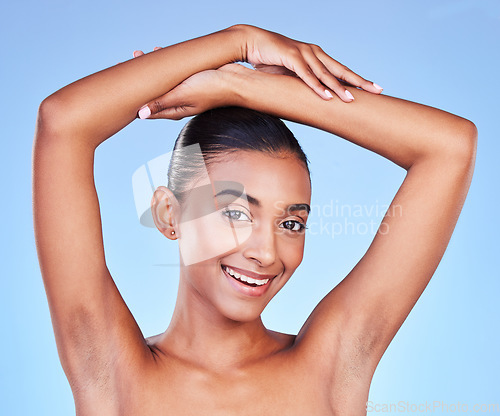 Image of Armpit, hair removal and woman in portrait with beauty, grooming and smile isolated on blue background. Hygiene, cleaning body and epilation with skincare, cosmetics and dermatology in a studio