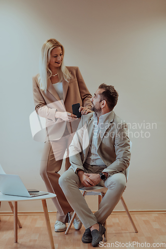 Image of A business couple posing for a photograph together against a beige backdrop, capturing their professional partnership and creating a timeless image of unity and success.