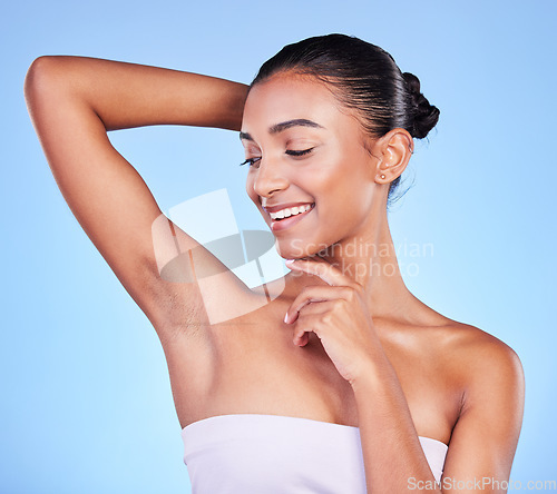 Image of Body care, smile and woman in studio with armpit, cleaning and BO control on blue background. Smooth skin, hygiene and happy female model with laser, hair removal or underarm treatment satisfaction