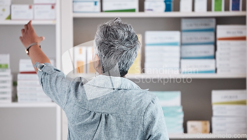 Image of Patient, pharmacy and pharmaceutical shelf in self medication, healthcare or boxes at the drugstore. Back view of customer reaching for medical product, healthy supplements or antibiotics at clinic